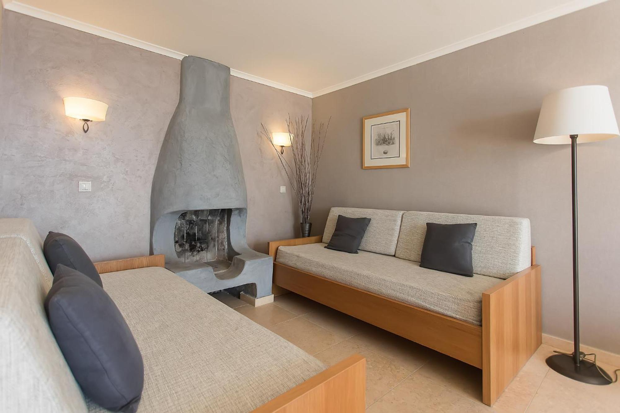 โรงแรมคอร์ฟูฮอลิเดย์พาเลส เปรามา ภายนอก รูปภาพ A living room with a fireplace